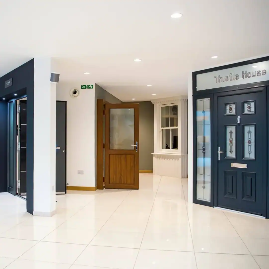 Bright door showroom in Aberdeen, Scotland, featuring composite entrance doors with decorative glazed panels and tiled flooring.